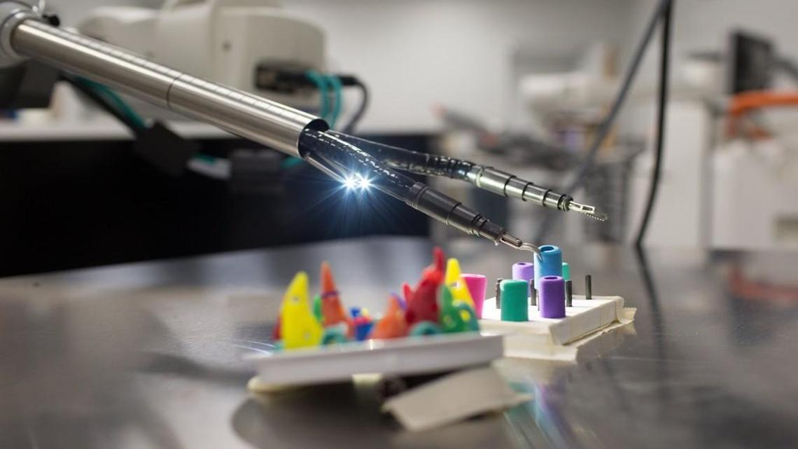 Katy Fitzgerald moves pegs using SurgiBot, a surgical robot designed by TransEnterix, Thursday, March 31, 2016 in Raleigh, N.C.