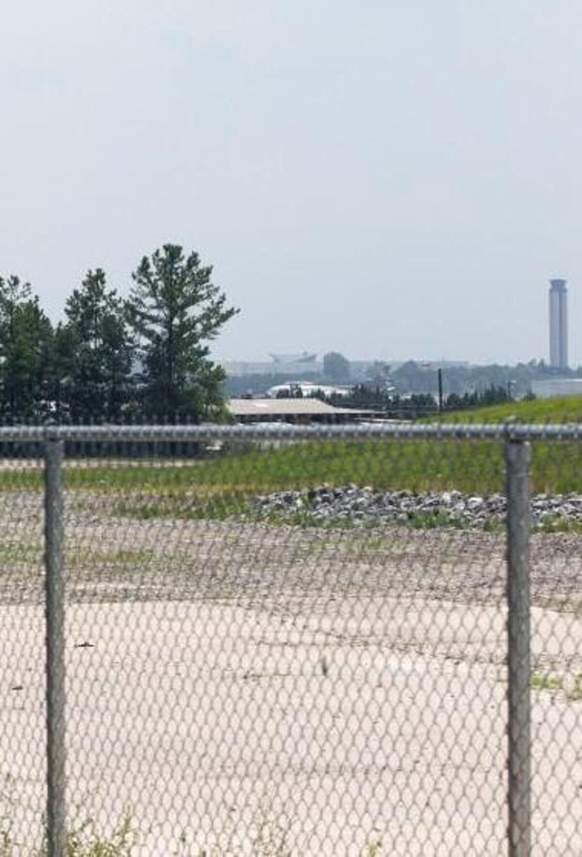An American Airlines jet approaches Raleigh-Durham International Airport for landing above the fenced site of the former Ward Transformer company off Lumley Road in July 2014. The facility was the source of PCBs that contaminated the site as well as a stream that flows from it.