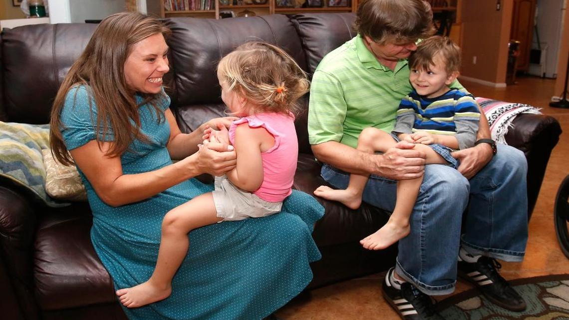
In this Wednesday, Sept. 30, 2015 photo, from left, Julie Armstrong, left, Amelia Anderson, Nathan Anderson and Dean Anderson sit on a couch at their home in Tucson, Ariz. Majoring in psychology, Anderson hoped to become a child psychologist. But after suffering a shoulder injury while playing soccer, he found relief only from an acupuncturist. Eventually he became a licensed acupuncturist himself in 2004. He had already racked up $45,000 in college debt; acupuncture school required more.
