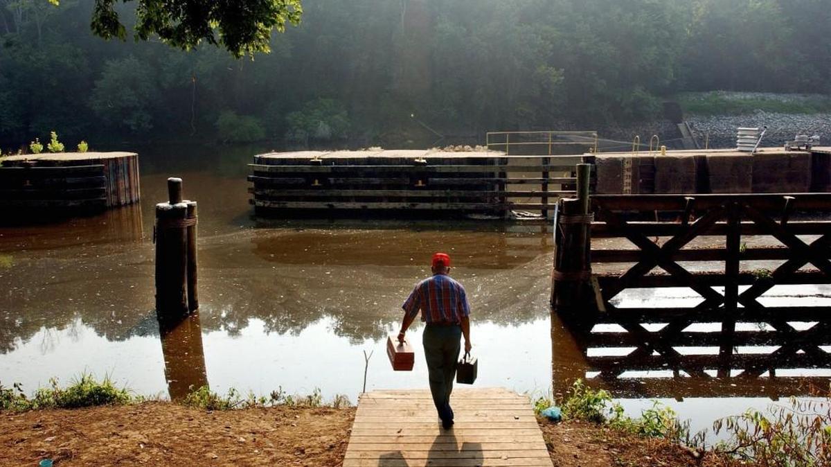 Billy Locklear, from Robeson County, brings his tackle box down to the shores of the Cape Fear River at the William O. Huske Lock and Dam off NC 87 in Bladen County Thursday morning July 22, 2004.