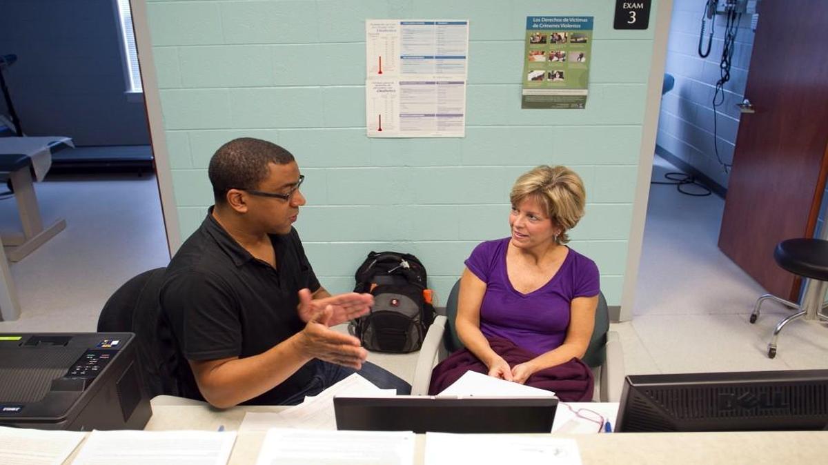 Affordable Care Act Navigator Keith Ward works with Cindy Murray of Knightdale, N.C. helping her through the steps of enrollment at Alliance Medical Ministry in Raleigh, N.C.