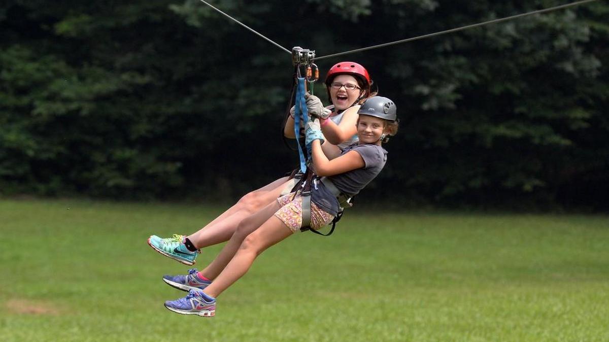 Kaylie Dake, (left) 11, of Walkertown and pal Sydney Witt, 11, of Winston-Salem ride a tandem zip line with a group visiting Carolina Ziplines Canopy Tour near Westfield, N.C., Wednesday, July 1, 2015.
