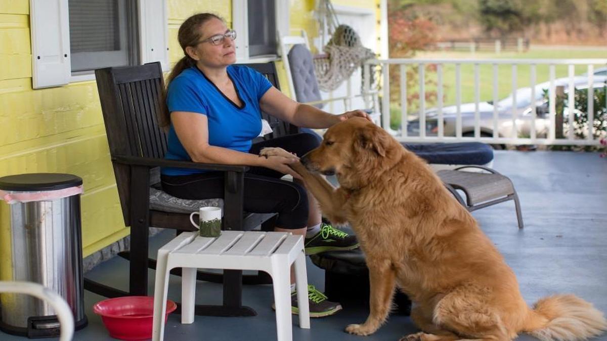 Linda Hammock meditates on her front porch in the company of her dog Bear during her morning routine.