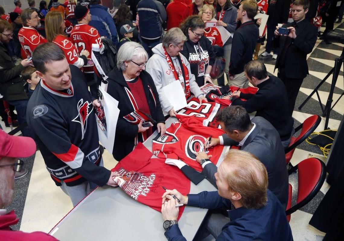 Canes 2006 team members, bottom, from left, Glen Wesley, Ray Whitney and Chad LaRose, sign autographs for fans before a 2016 game with the New York Islanders at the PNC Arena in Raleigh.