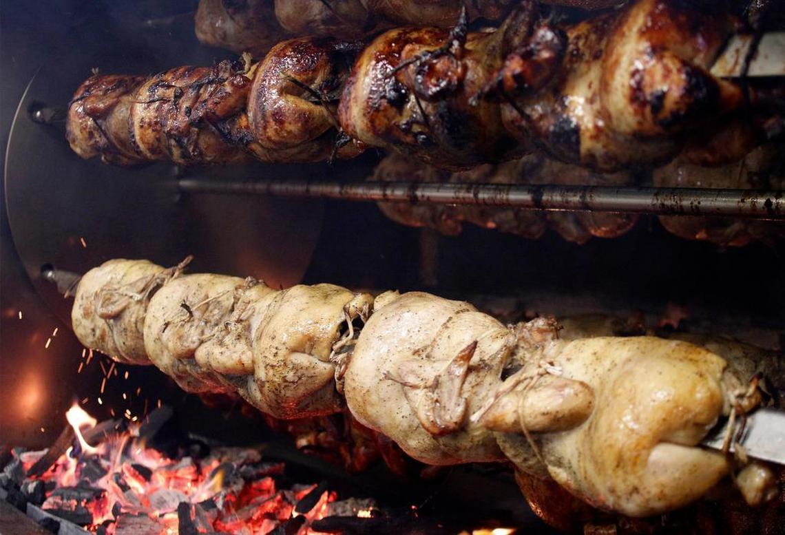 Chicken cooks over wood charcoal briquettes at Mami Nora's on July 16, 2015 in Cary, NC. 
