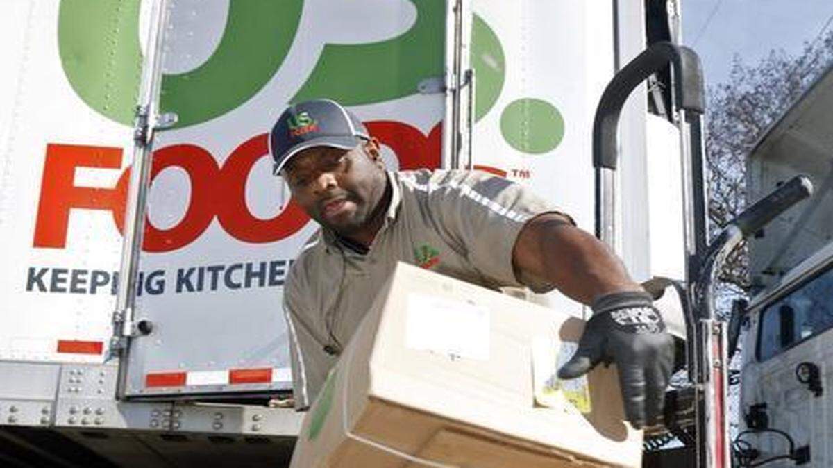 
US Foods delivery driver Reggie Rollock unloads several large boxes of frozen foods Thursday morning, April 2, 2105 for his client 18 Seaboard restaurant during his twice a week delivery stop in downtown Raleigh. A proposed merger of Sysco and US Foods is causing much commotion and uncertainty among Triangle restaurant owners.
