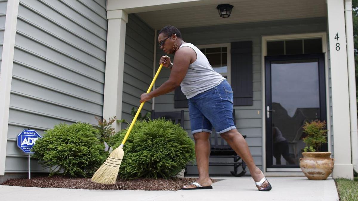 
Angela Devone sweeps her front porch on Thursday, July 2, 2015, in Clayton, NC. The NC Foreclosure Prevention Fund is designed to help homeowners avoid foreclosure. 
