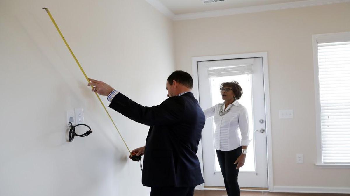 Evelyn Little checks the dimensions of her new home in Carolina Arbors with realtor Keith Bliss. She is moving from a condo in Briar Creek to the Carolina Arbors retirement community a few miles away.