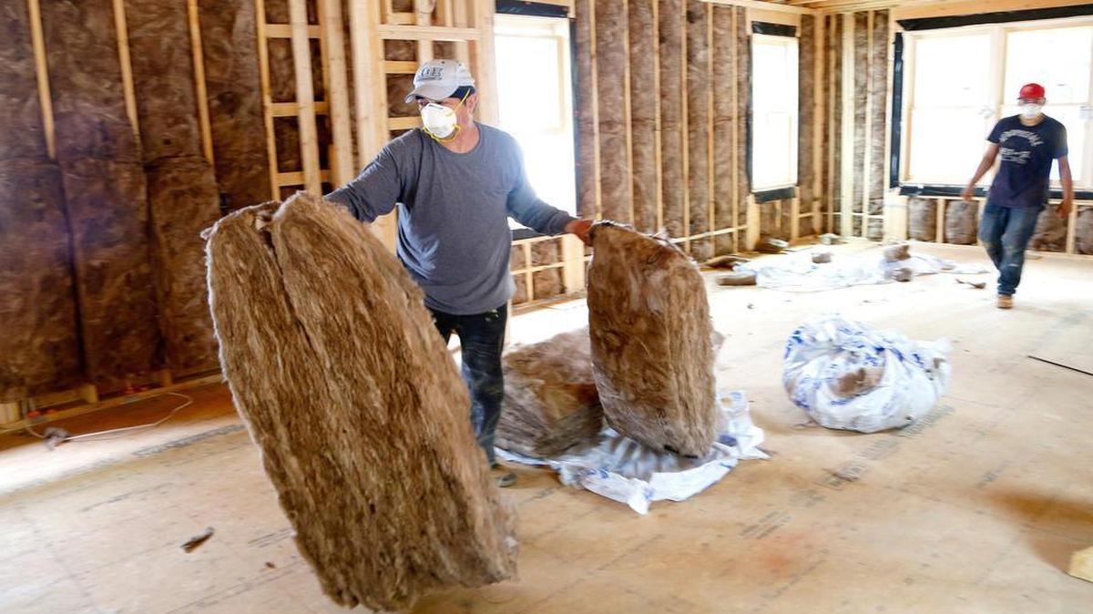 
Jose Buendia, left, installs insulation in one of the houses on Wynne Street in Raleigh on July 8, 2015. The Raleigh Architecture and Construction Co. are building three modernist houses on the street. The project is the latest example of the rapid gentrification going on east of downtown.
