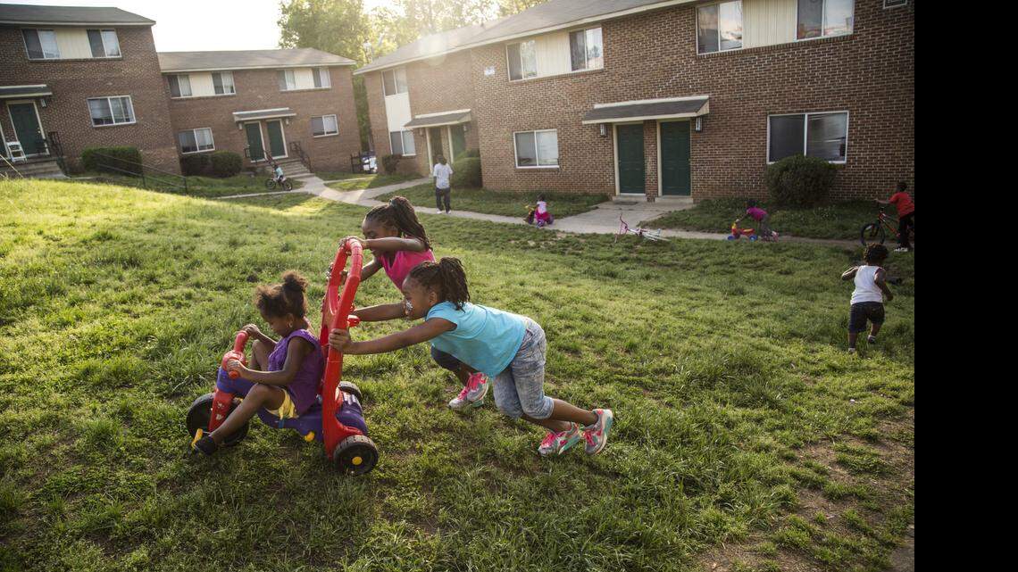 
Aniyah Ferguson, 4, is pushed by Aaliyah Whitley, 6, and Oriana Whitley, 7, foreground, in the yard at the Raleigh North Apartments in Raleigh. It’s one of the larger affordable housing communities remaining near downtown.  
