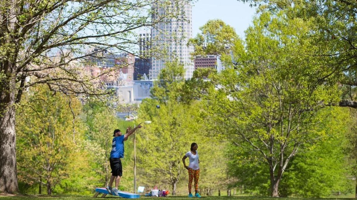 Richard Hardison, left, and Christa Vick, right, play cornhole in front of the Downtown Raleigh skyline at the first Spring Fling at Dix Park in Raleigh, N.C. on Sunday, April 9, 2017.