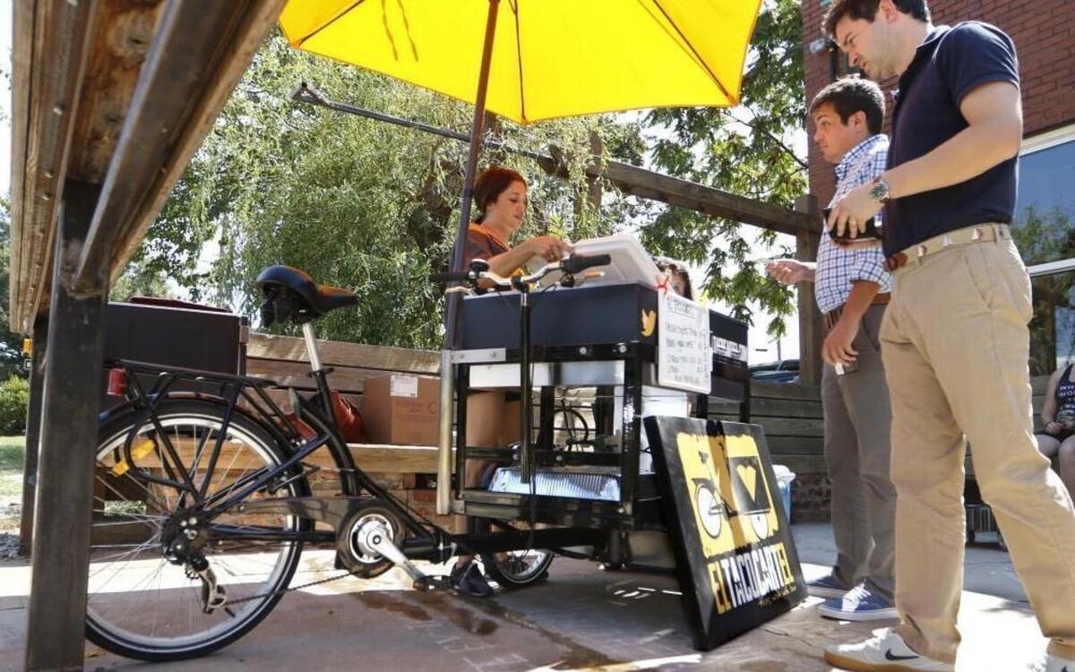 Lily Ballance, background, co-owner of the El Taco Cartel taco bike, works Friday, September 9, 2016 outside Crank Arm Brewing in Raleigh. The new taco vendor opened up on September 1, 2016 selling taco varieties after more than a year's effort to create the bike/cart hybrid vehicle and get approved by the city of Raleigh.