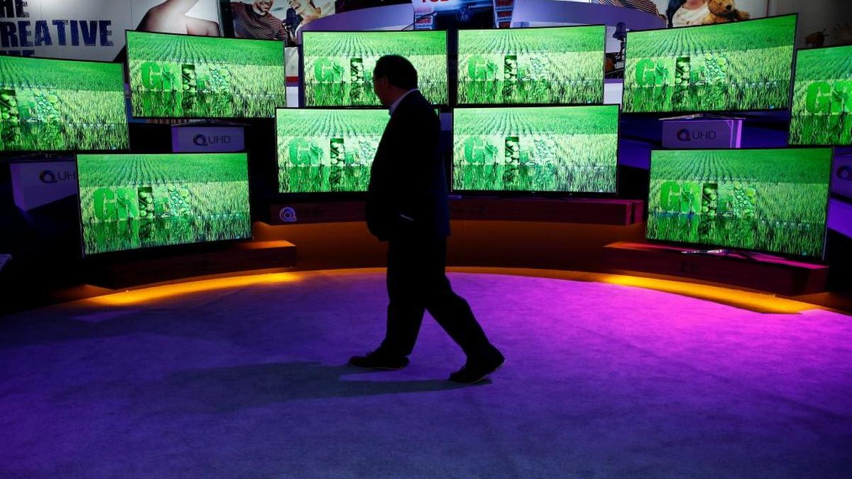 A man walks by ultra high definition TVs at the TCL booth at CES International, Wednesday, Jan. 6, 2016, in Las Vegas.
