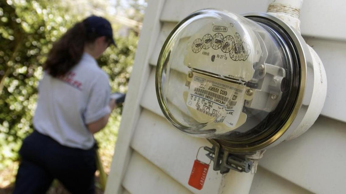A meter reader reads a customer’s electric meter and keys the information into a handheld computer. Duke Energy wants customers who don’t want a smart meter to pay a $150 one-time fee and $11.75 a month to cover the costs of manual meter reading.