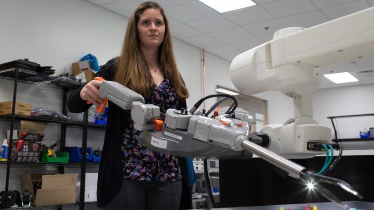 Katy Fitzgerald moves pegs using SurgiBot, a surgical robot designed by TransEnterix.