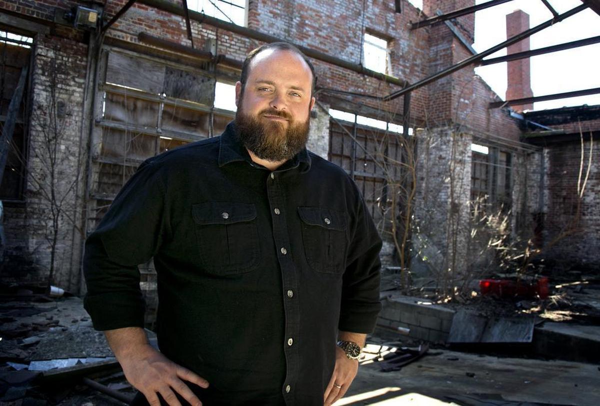 Jason Queen, 36, of Raleigh, poses at the Carolina Coach Garage and Shop (or Stone’s warehouse) on East Davie Street in downtown Raleigh,. He’s planning to restore 26,000 square feet across the two historic buildings.