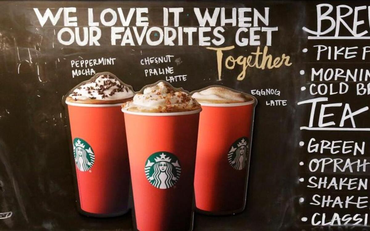 Red paper cups are featured on a chalkboard menu behind the counter at a Starbucks coffee shop in the Pike Place Market, Tuesday, Nov. 10, 2015, in Seattle. It's as red as Santa's suit, a poinsettia blossom or a loud Christmas sweater. Yet Starbucks' minimalist new holiday coffee cup has set off complaints that the chain is making war on Christmas.