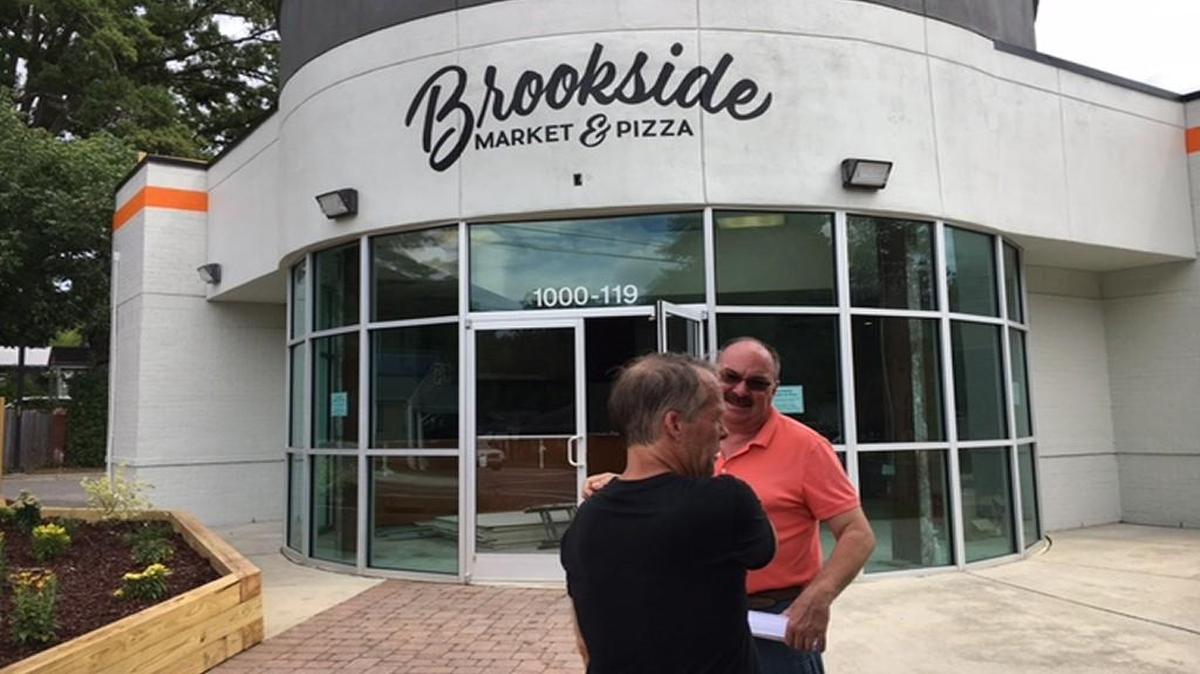 Developer Duane Williams, front, and operations manager Mark Brown outside the Brookside Market & Pizza building that is being renovated.