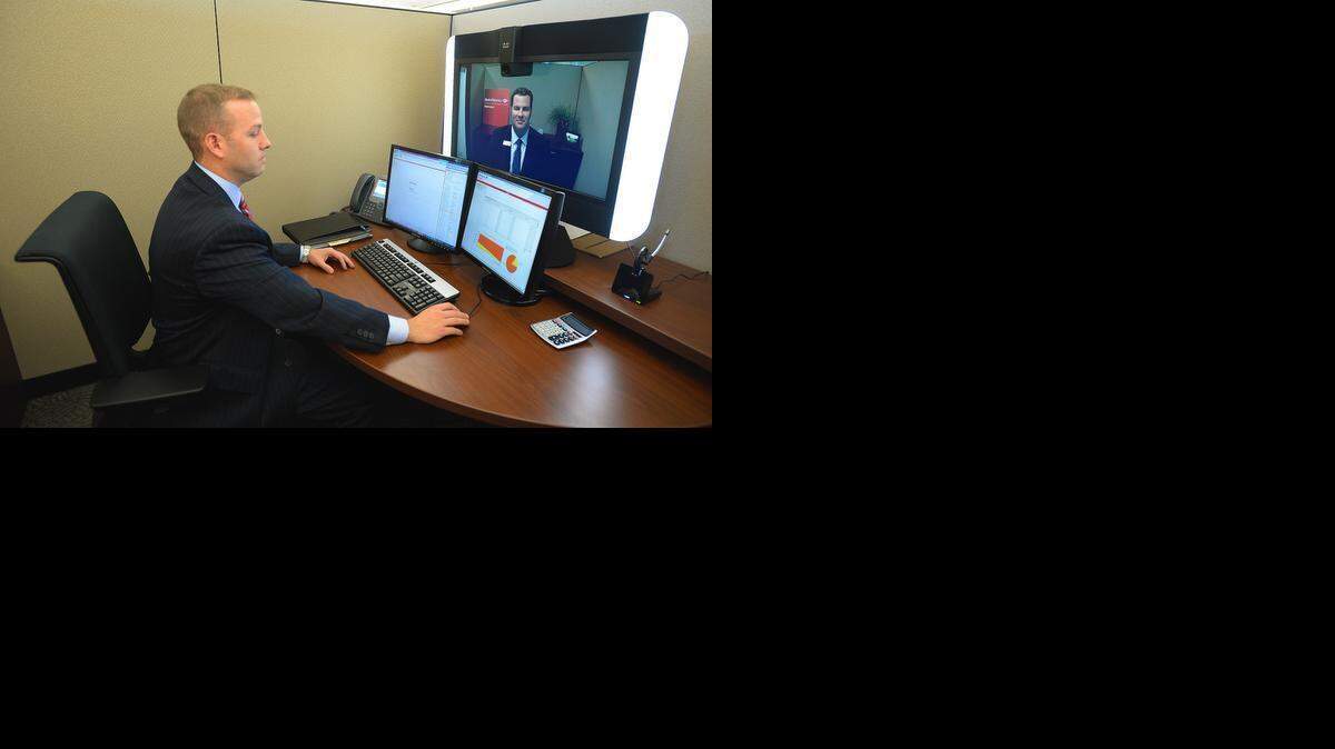 
Steve Soccio, a Bank of America sales manager in Charlotte, demonstrates how a mortgage banker in a call center would interact on video with a customer in a branch. The Charlotte-based bank is putting video screens in branches where foot traffic is too low to justify having a specialist banker in the branch. The screens allow customers to talk to bankers who are housed in call centers in Charlotte and elsewhere.

