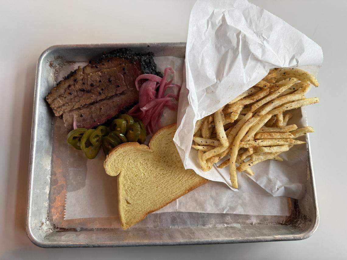Smoked meat at Lawrence Barbecue is sold by weight and served with a slice of bread.