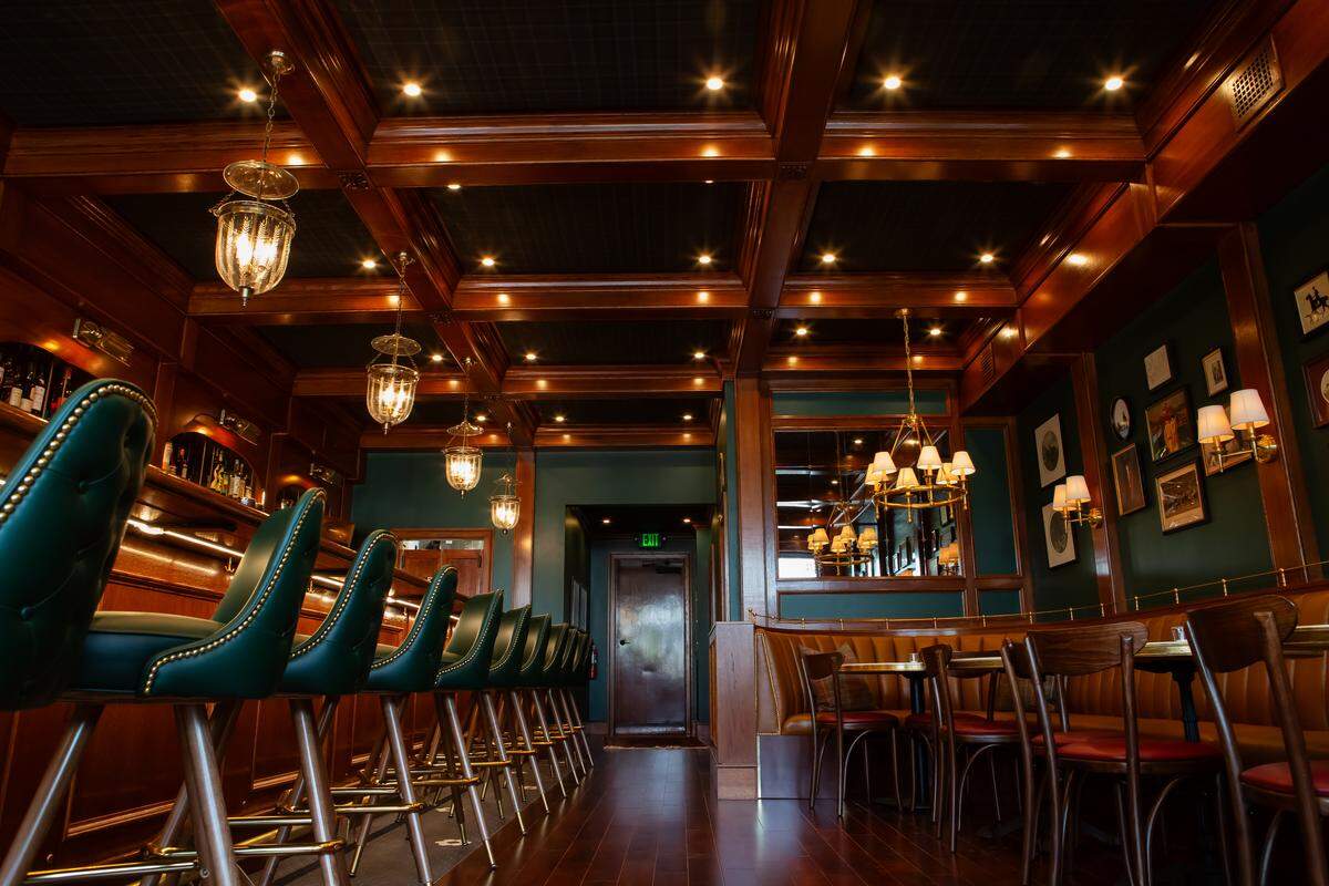 The cocktail bar Mr. Henry has dark green and dark wood accents throughout.