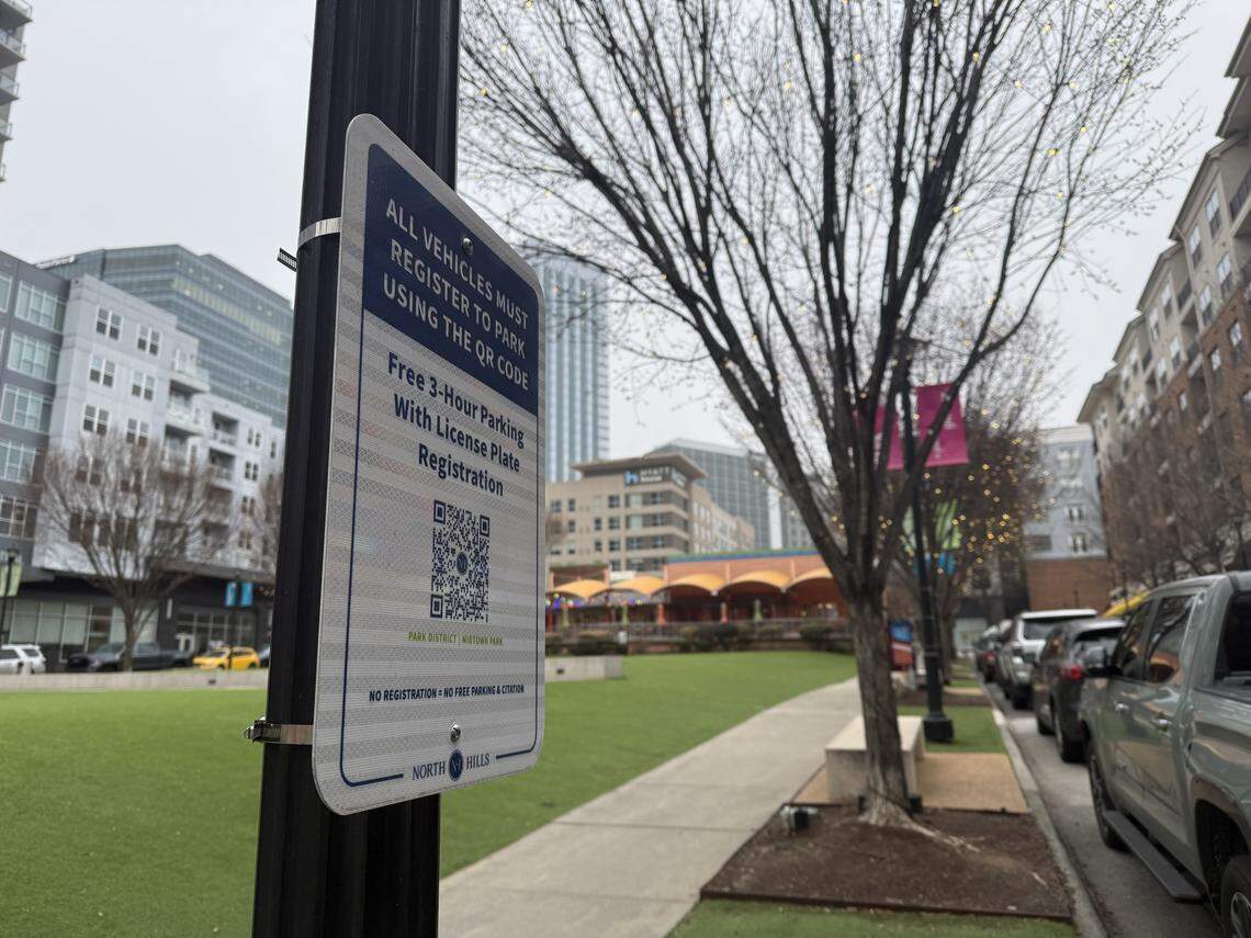 Signs are posted along Midtown Park in the Park District of North Hills, prompting drivers to register their vehicles to avoid fines.