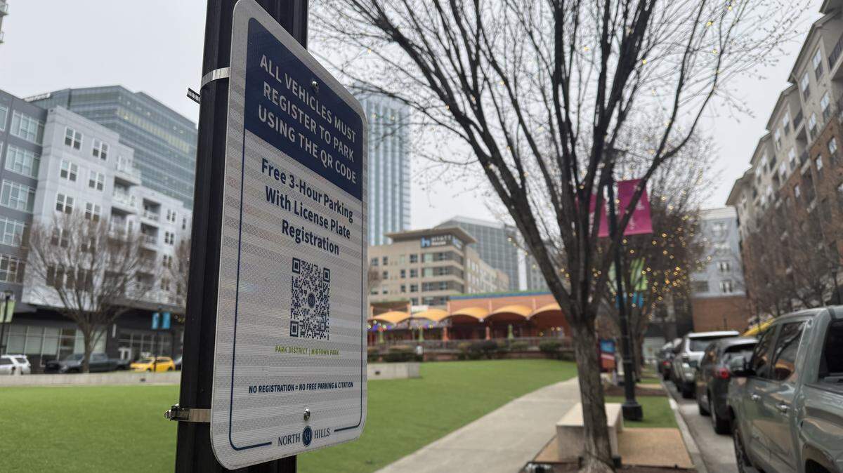Signs are posted along Midtown Park in the Park District of North Hills, prompting drivers to register their vehicles to avoid fines.