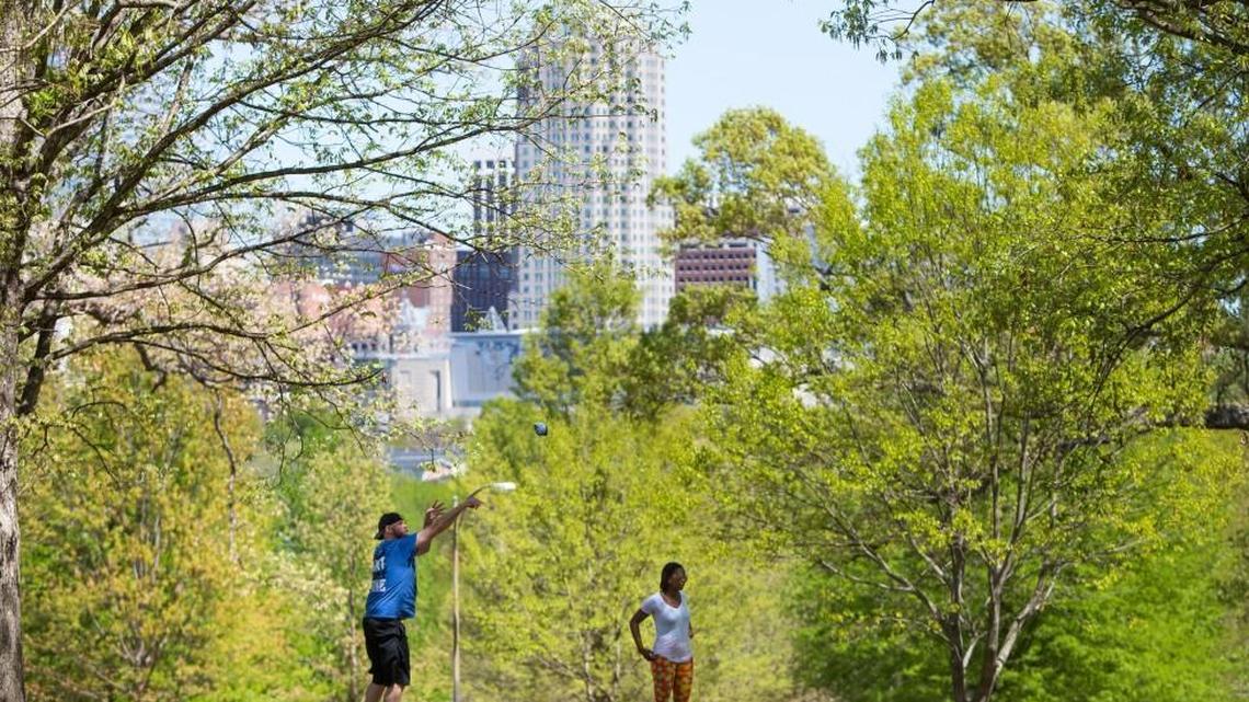 Richard Hardison, left, and Christa Vick, play cornhole in front of the Downtown Raleigh skyline at the first annual Spring Fling at Dix Park in Raleigh Apr. 9, 2017.
