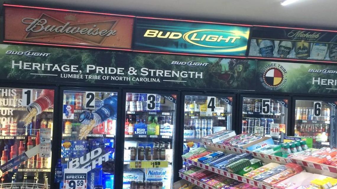The Lumbee logo, top right, used with the “Heritage, Pride & Strength” slogan in an advertisement for Bud and Bud Light in a Lumberton convenience store. The Lumbee Tribe of North Carolina filed a lawsuit in federal court on Tuesday accusing Anheuser-Busch and R.A. Jeffreys Distributing Company of illegally using the logo.