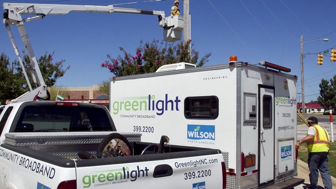 Greenlight Community Broadband employee Chris Hedrick (in bucket) installs a fiber optic unit on Forest Hills Road in Wilson, N.C. on Wednesday, August 27, 2014.