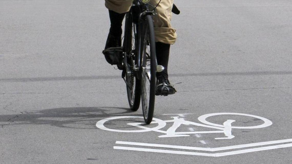 
Francois Birgand, assistant professor with N.C. State, rides his bicycle on Clark Avenue over a "sharrow" or shared-right-of-way marker, which is designed to help vehicle drivers be aware of bicycle traffic.

