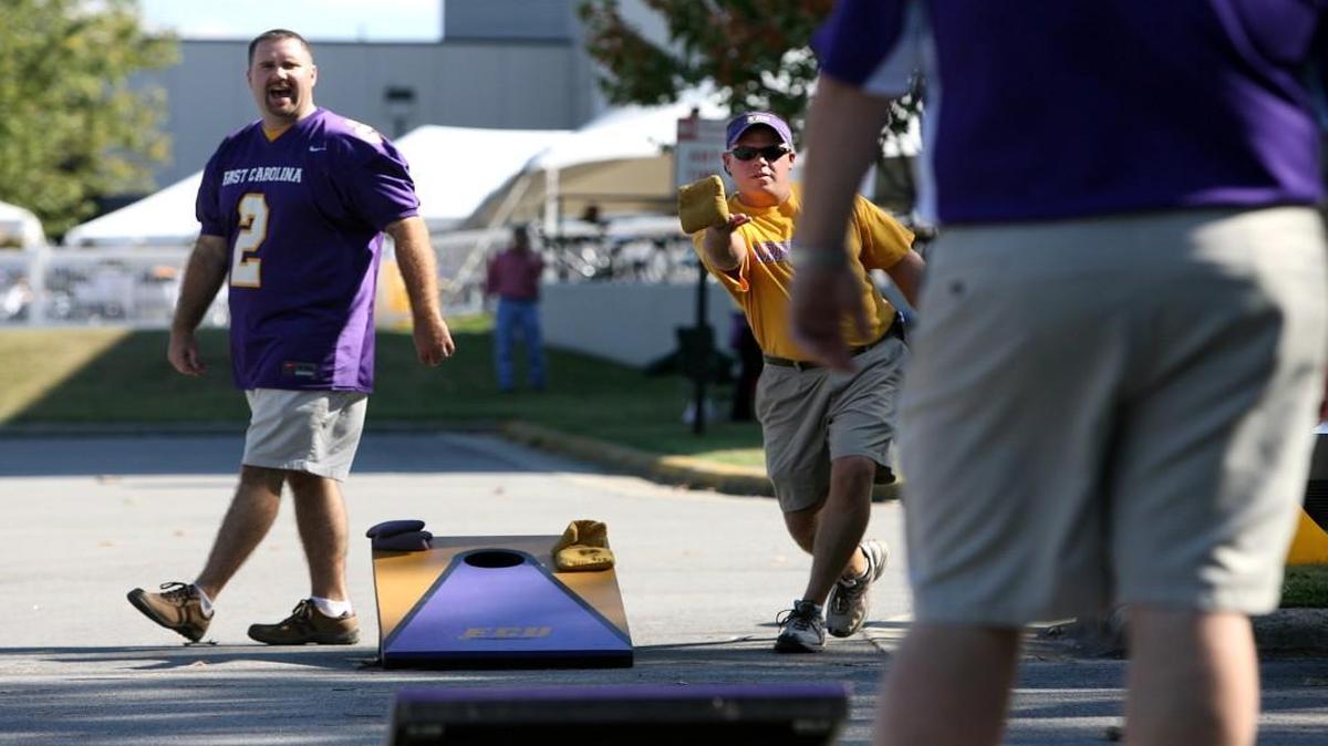 Brian Fleming, right, of Greenville, and Harry Bray, left, of Blanch, N.C. play cornhole in the parking lot outside Dowdy-Ficklen Stadium in Greenville while tailgating before ECU's game with N.C. State.