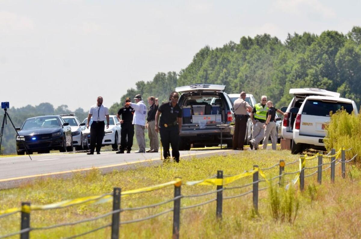 Investigators from several agencies work the scene after a vehicle crashed and officials were involved in a shooting on westbound Interstate 40 near Benson, N.C. Saturday, July 8, 2017.