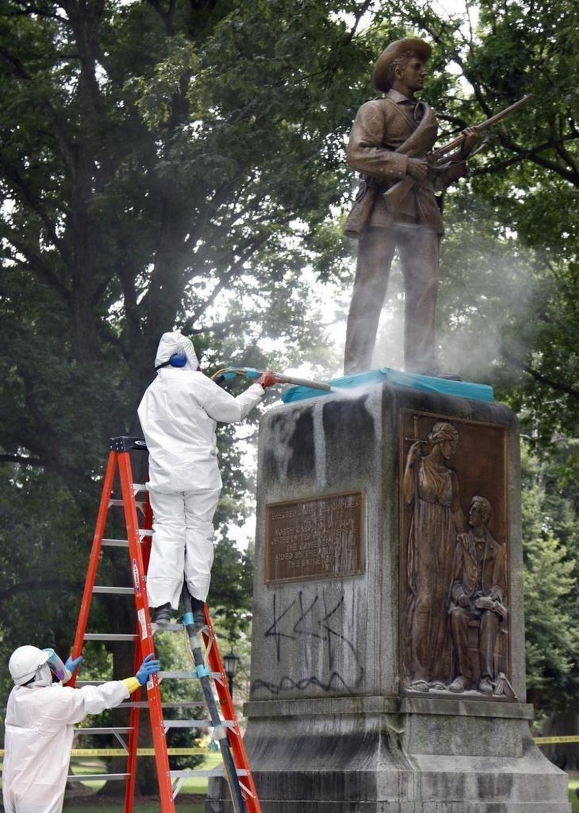 A CCI Environmental Services worker blasts one face of the sandstone base of the Silent Sam monument on the UNC-CH campus removing black acrylic spray paint Tuesday, July 7, 2015