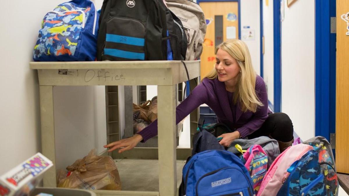 Melissa Plum, a social worker at Lynn Road Elementary School in Raleigh, packs book bags with food in this 2015 file photo. Plum delivered the bags to students who were part of the Backpack Buddies program.