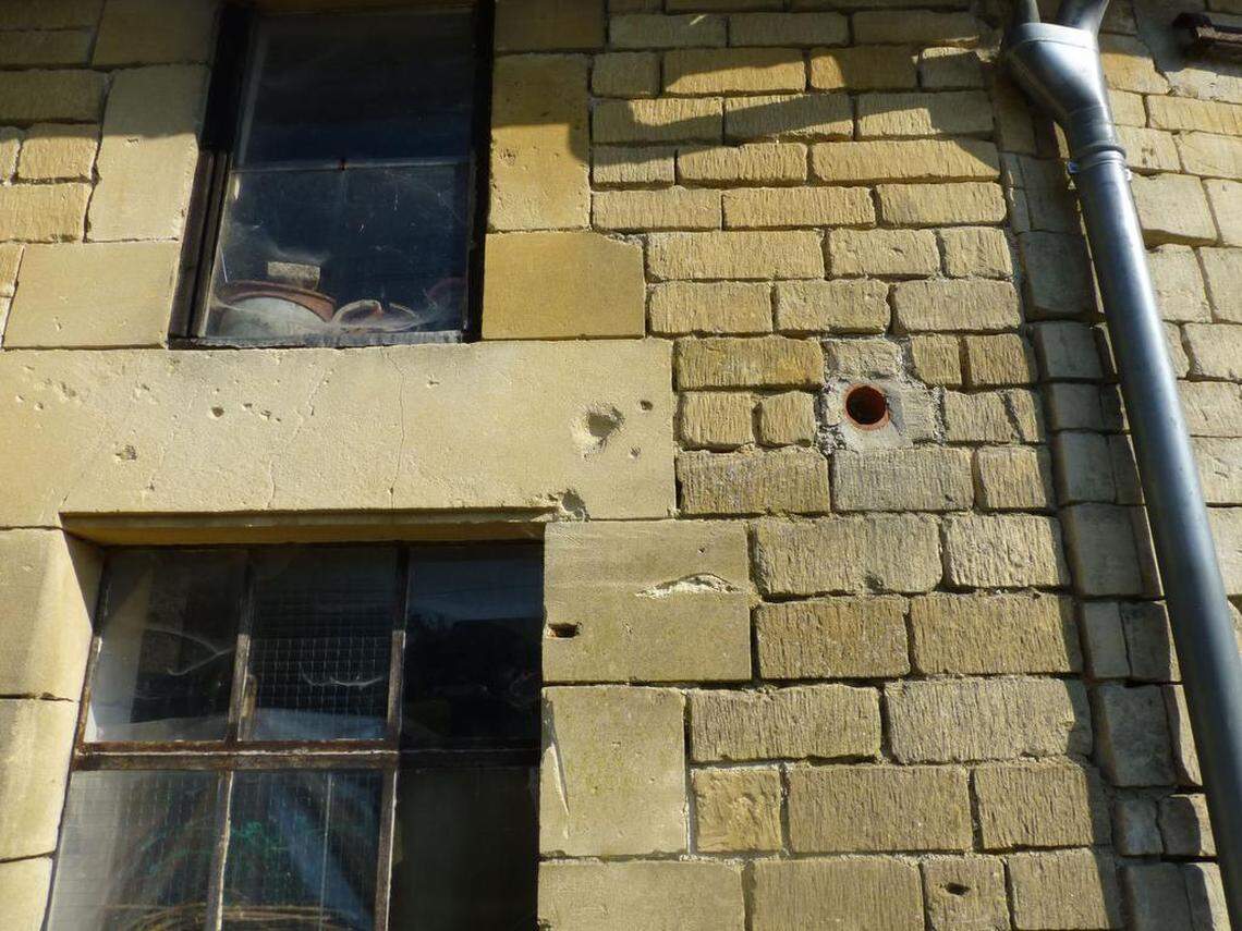 Battle-scarred walls of buildings in the village of Bayonville, France.