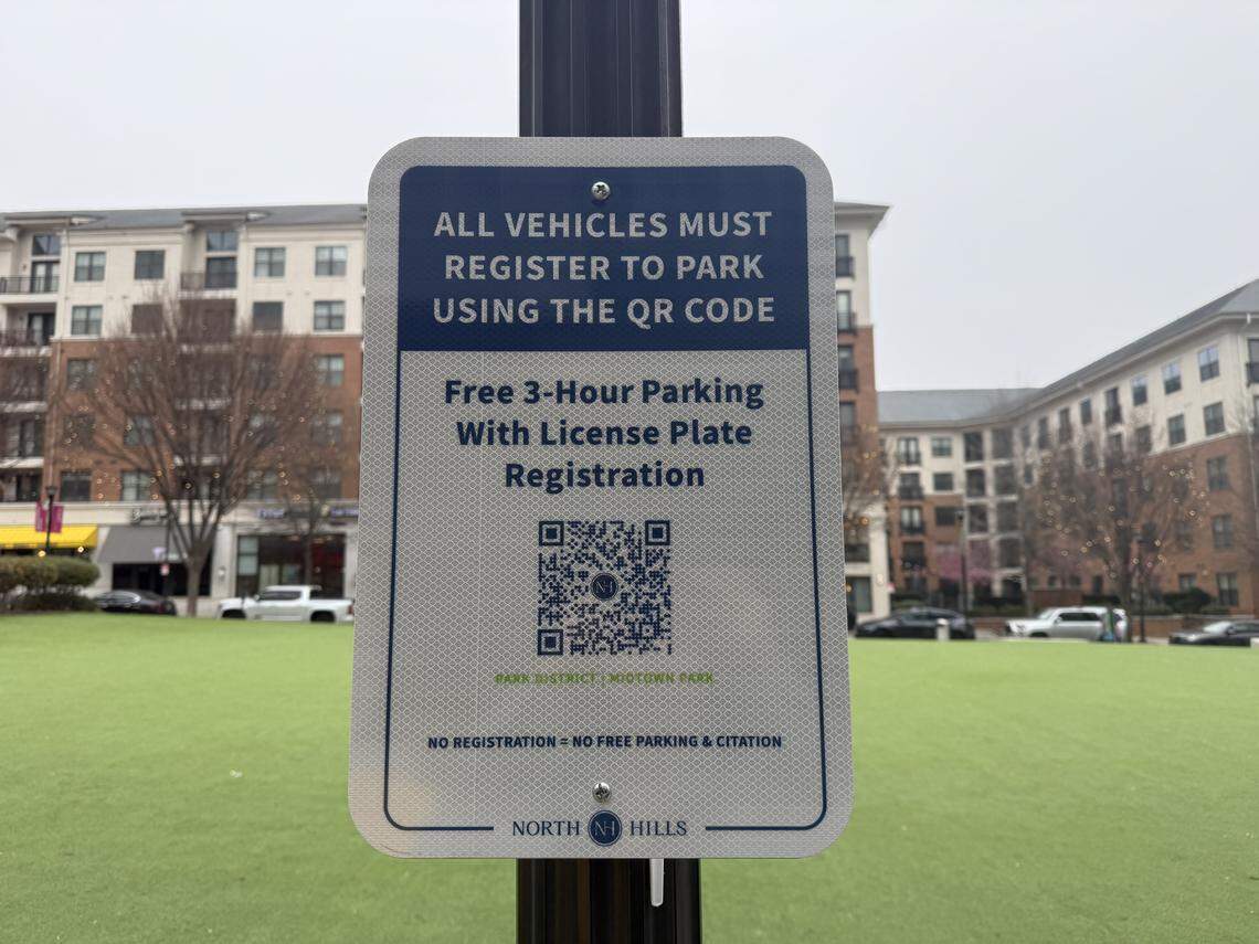 Signs with QR codes posted along Midtown Park in the North Hills Park District prompt visitors to register their vehicles to park.
