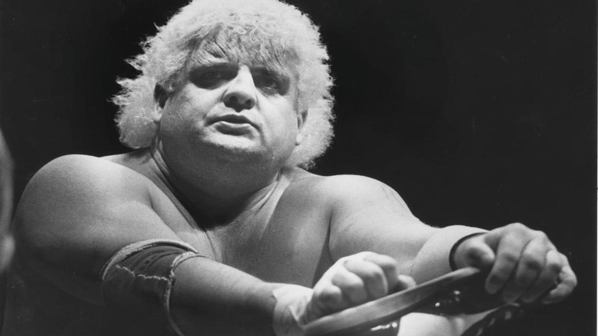 
Professional wrestler Dusty Rhodes, known as ‘The American Dream,’ toys with an opponent’s foot during a bout at Raleigh’s Dorton Arena in 1985. Rhodes, who died Thursday at age 69, cultivated a blue-collar, non-buff wrestling persona than won him many fans.
