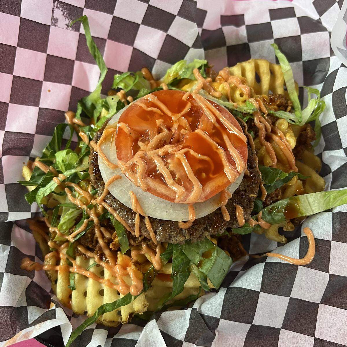 The Dirty V’s take on a trash plate, the Trash Talker, features waffle fries topped with a burger patty, chili, shredded lettuce, tomato, onion and sauce.