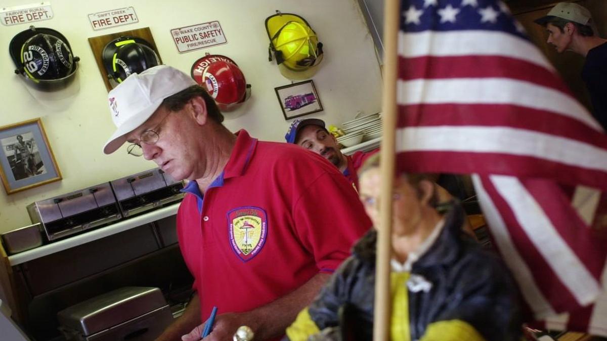 Barry Doyle, left, takes care of customers in 2009. Firefighting memorabilia sent by fire departments all over the country and even abroad show of appreciation for his generosity toward firefighters and first responders.
