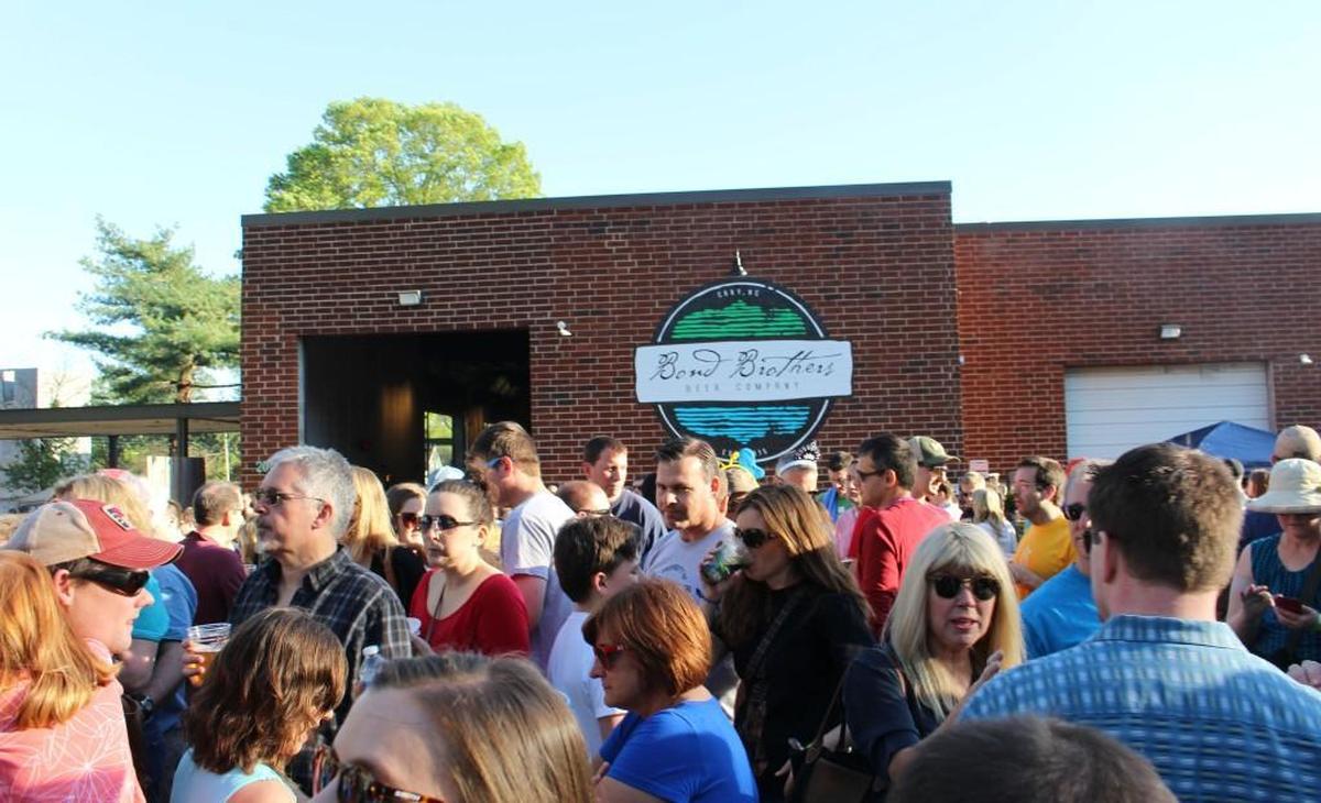 Hundreds of people flood East Cedar Street Saturday, April 2, 2016, in downtown Cary to enjoy local beer, food and music at the Bond Brothers Beer Company grand opening celebration.