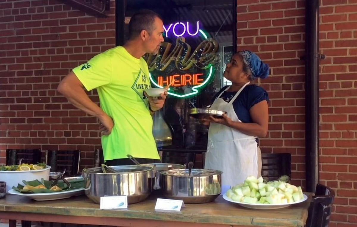 Vimala Rajendran, left, owner of Vimala’s Curryblossom Cafe, shares a meal and conversation with a class from Franklin Street Yoga Center on Saturday, Sept. 19, 2015.