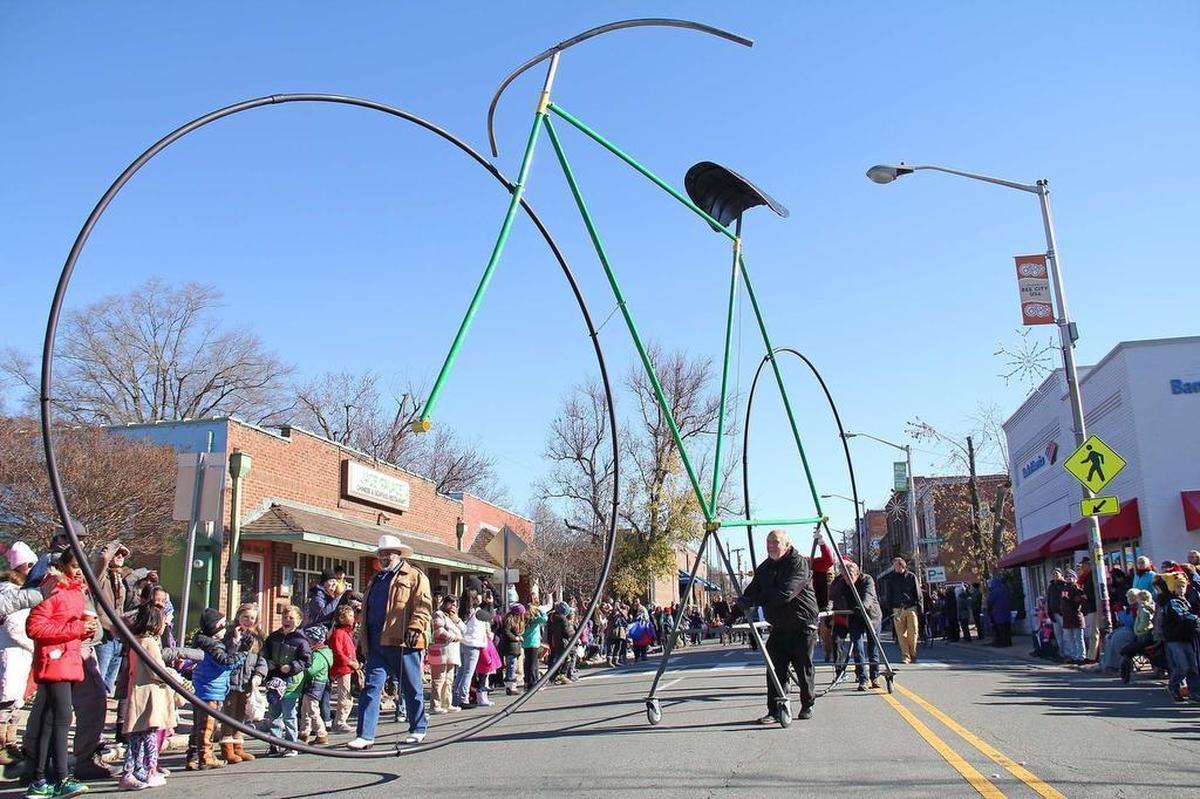 Peck & Artisans of Carrboro drive a really big bike down Main Street during the 2016 Chapel Hill-Carrboro Holiday Parade.