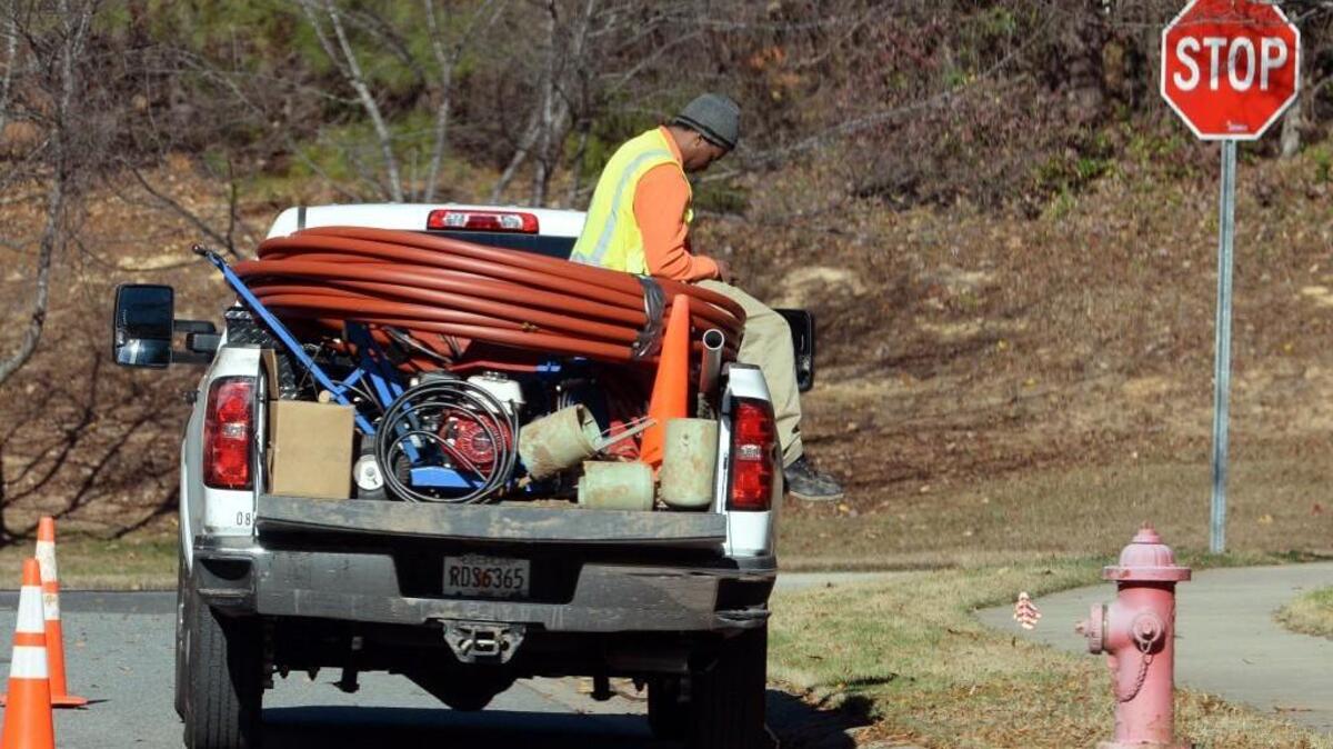 A worker for Synchronicity waits for the rest of his work crew near Woodcroft Parkway in Durham, N.C. Friday, Dec. 2, 2016.