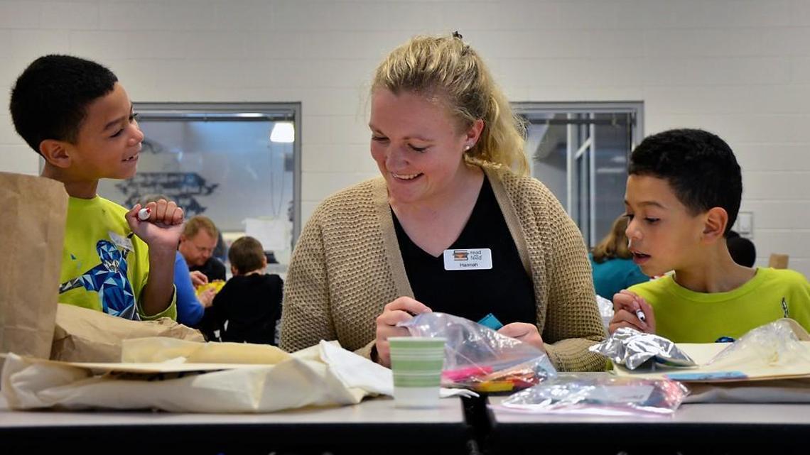 Hannah Byers, a volunteer with the Read and Feed program, works with twins Yeriel (left) and Ediel Cabrera at the Zebulon Boys & Girls Club in this 2015 file photo.