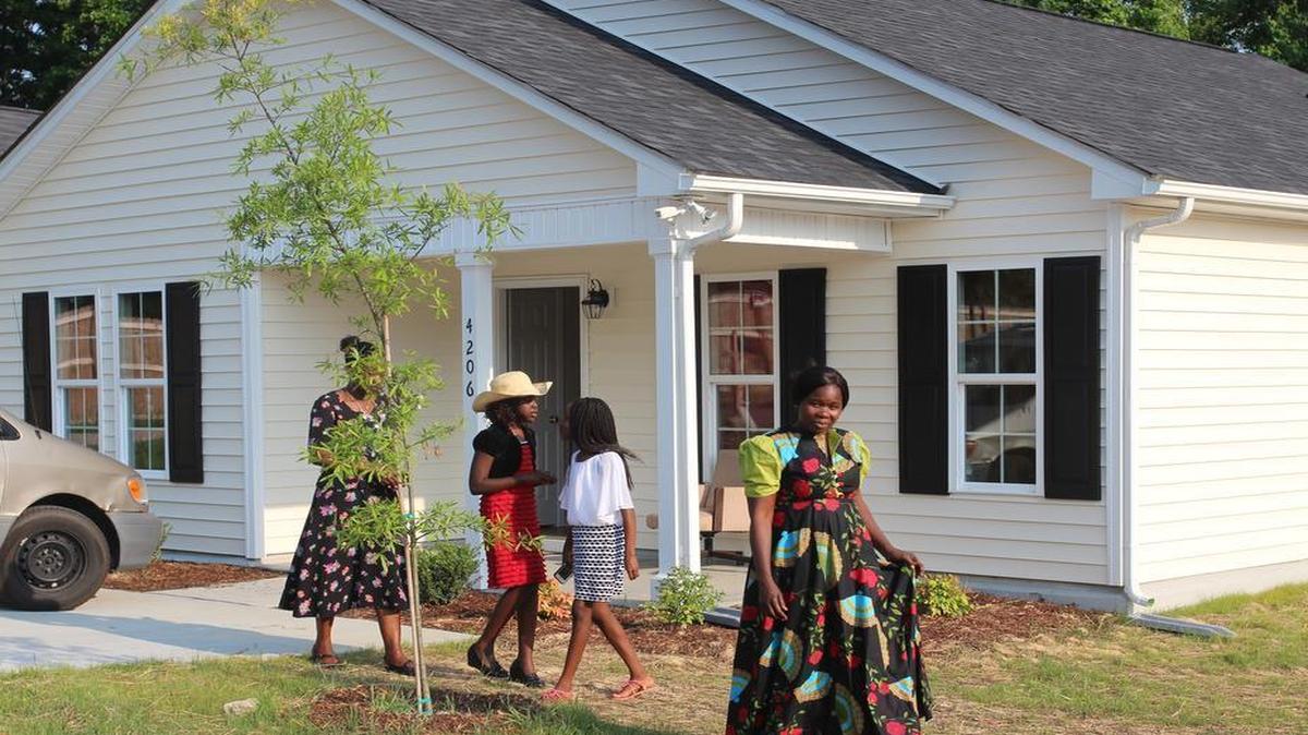 Flora Mohammed walks outside her new home built by Habitat for Humanity of Wake County. Mohamed, who was homeless, received help from several local nonprofit groups throughout her journey to homeownership.
