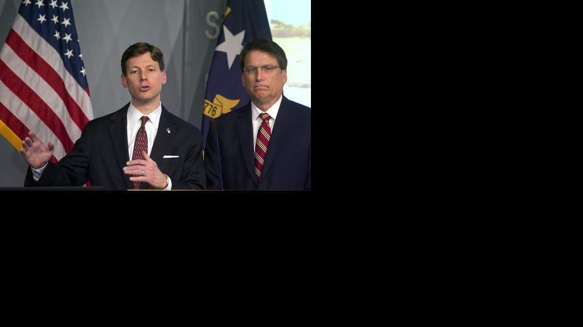 
State Budget Director Lee Roberts, left, addresses members of the media, as N.C. Governor Pat McCrory listens in the Joint Force Headquarters Media Briefing Room in Raleigh, N.C. on Thursday, March 5, 2015. They unveiled the governor's proposed 2015-2017 budget for the state.
