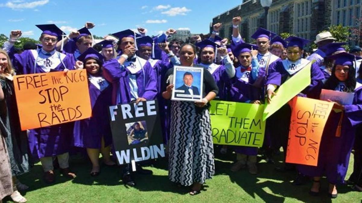 Dilsia Acosta is surrounded by Riverside High School graduates who were the classmates of her son Wildin Acosta, who remains in federal immigration custody.