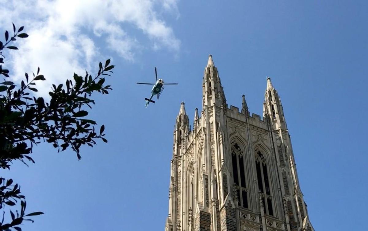 A helicopter flies over Duke University Chapel after a memorial service Wednesday, Sept. 20, 2017, for the Duke Life Flight crew and patient who died in a crash Sept. 8.