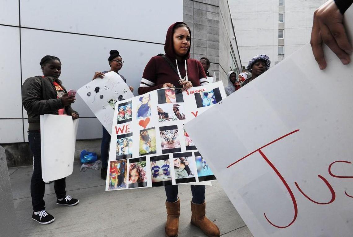 Tarshella Fountain, sister of Uniece "Niecey" Fennell, shows photos of Niecey during a protest outside the Durham County jail.